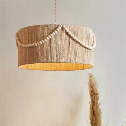 Eclairage suspension Suspension en fibre naturelle ornée de perle en bois